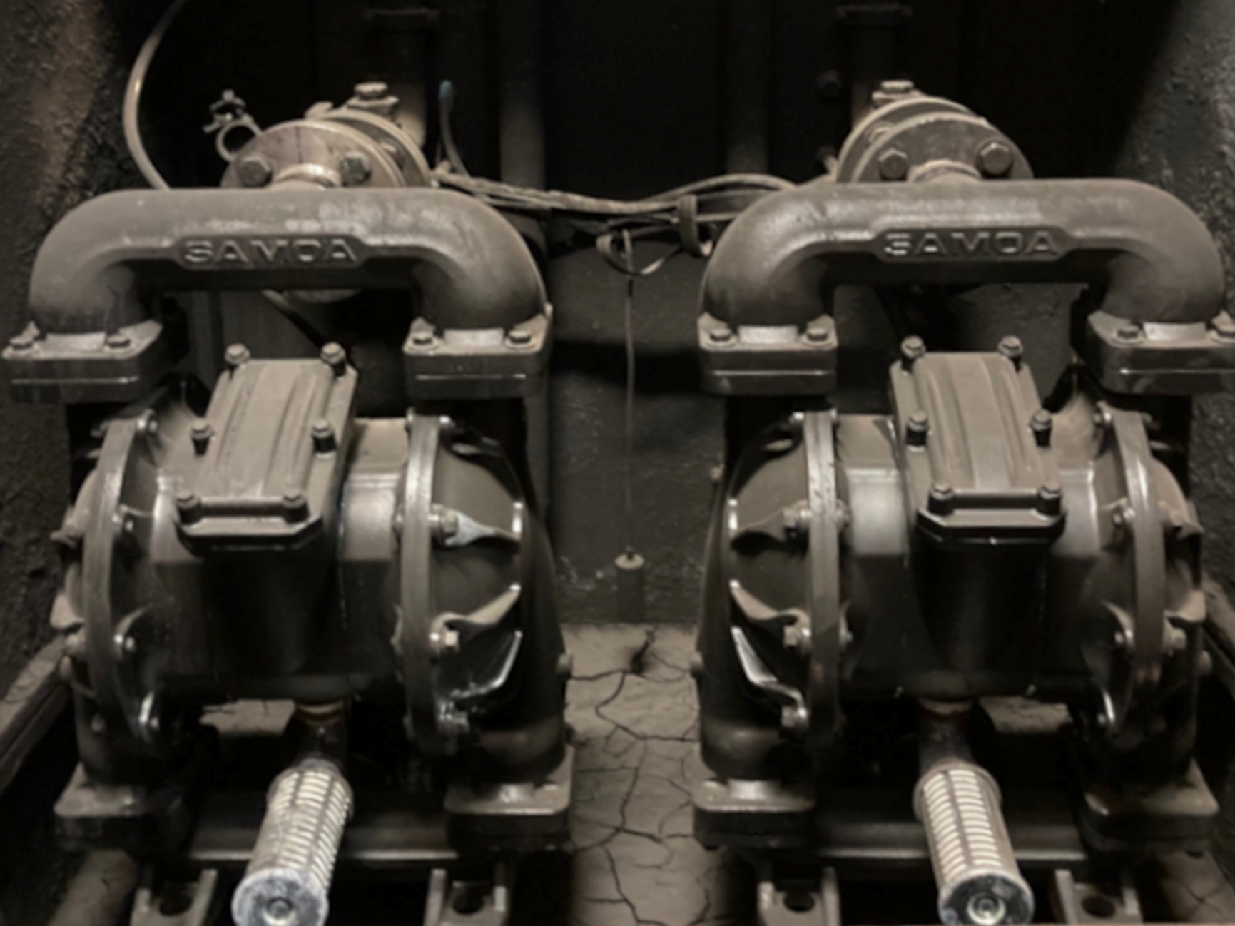 Pair of Samoa double diaphragm pneumatic pumps installed in a harsh industrial environment for transferring dense fluids